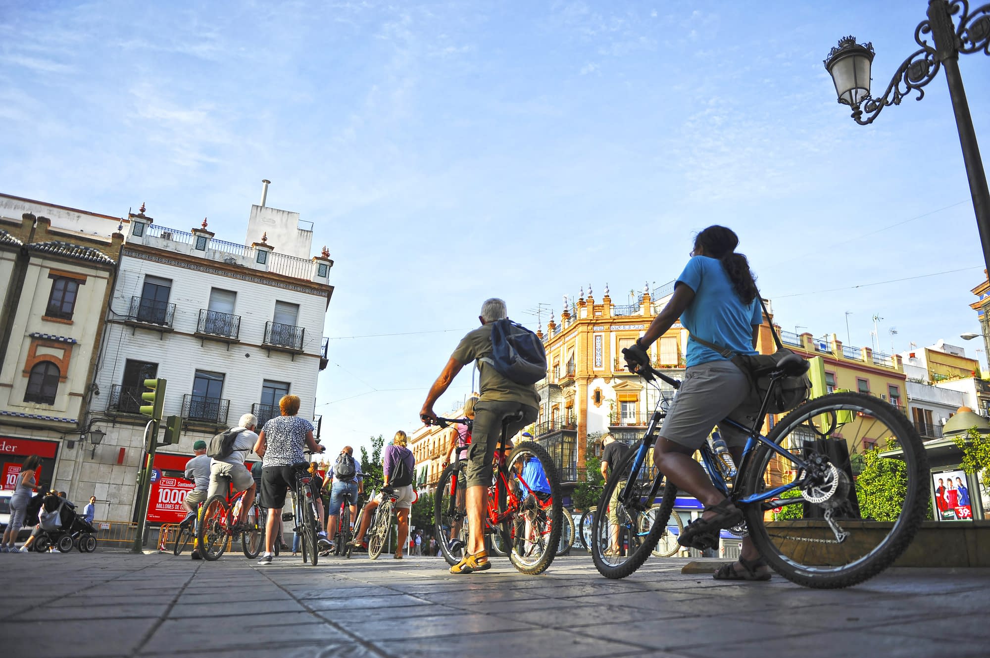 Tourists on bike tour through Triana neighborhood in Seville, Andalusia, Spain